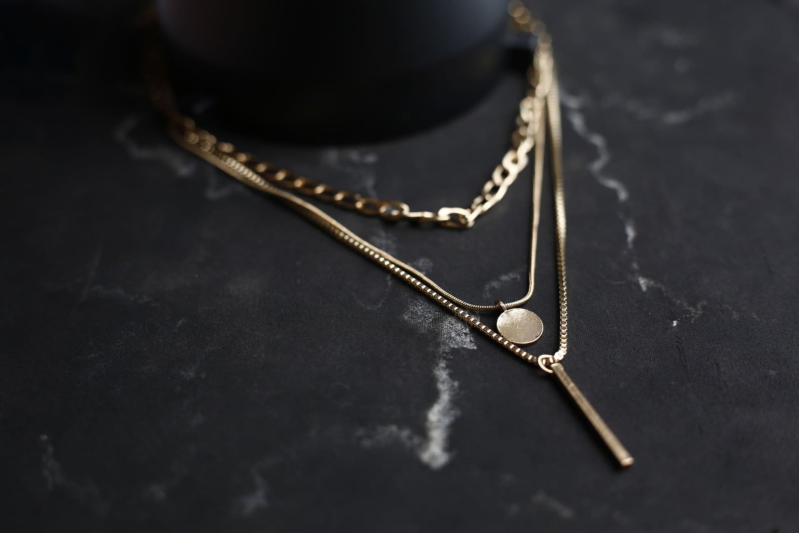 Colares de ouro sobre superfície preta, destacando o valor e a elegância de joias de luxo prontas para avaliação, venda ou penhor.